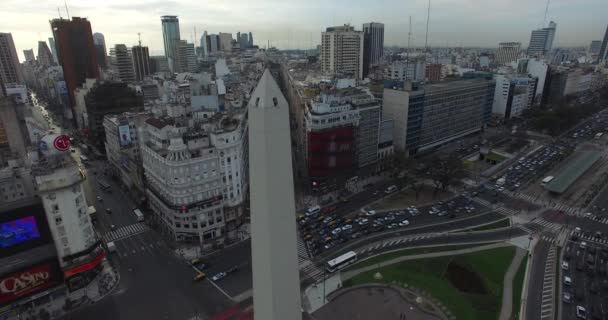 Escena aérea del Obelisco en Buenos Aires, Argentina, al amanecer de la mañana. Avenida principal 9 de Julio, 9 de julio. Tráfico y gente que va a trabajar. Cámara panorámica vertical . — Vídeos de Stock