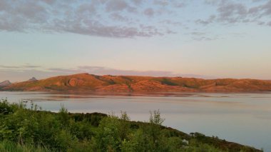 Gün batımı suyun üzerinde kayaların üzerine düştü.