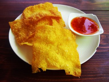 Kızarmış gevrek mantı sosu ile beyaz çanak üzerinde