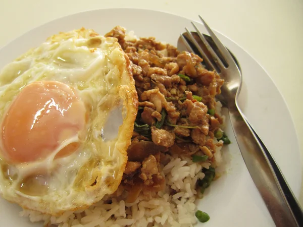 rice topped with stir fried pork and basil with fried egg, thailand traditional food