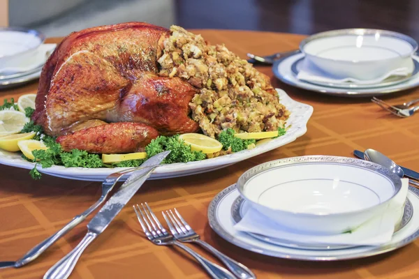 Garnished roasted turkey on fall festival decorated table with horn of plenty and red wine — Stock Photo, Image