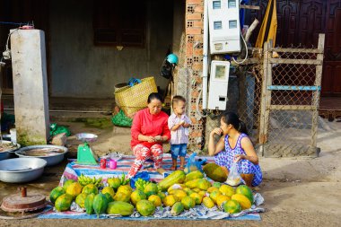 Long Hai, Vietnam - Aralık 29, 2014: Anne ve çocuğu sabahın erken saatlerinde Long Hai balık pazarında yerel meyve satmak, Long Hai, Vung Tau, Vietnam