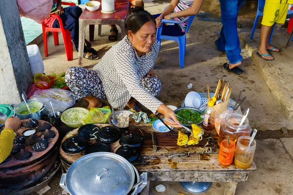 Long Hai, Vietnam - 29 de diciembre de 2014: Los vendedores de comida rápida vietnamitas (Banh Xeo y Banh Can) en el mercado de pescado Long Hai temprano en la mañana, Long Hai, Vung Tau, Vietnam — Foto de Stock