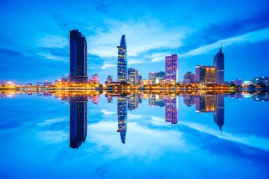 Reflection of Night view of Business District and Administrative Center of Ho Chi Minh city on Saigon riverbank. clipart