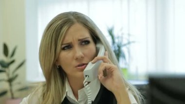 İş kadını telefonla konuşuyor. Kadın ofiste. Katip iş başında.