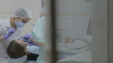 Diş hekimi ve diş asistanı gerçek diş cerrahisinde hasta dişlerde çalışma