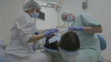 Diş hekimi ve diş asistanı gerçek diş cerrahisinde hasta dişlerde çalışma