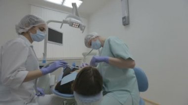 Diş hekimi ve diş asistanı gerçek diş cerrahisinde hasta dişlerde çalışma
