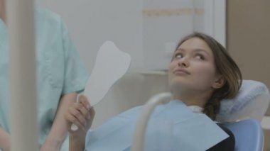 Gülümseyen genç kadın diş kontrolü yaptırıyor..