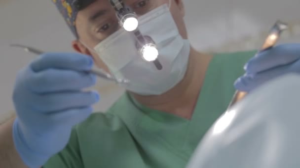 Concentreren op close up van tandarts met masker werken op patiënt. — Stockvideo