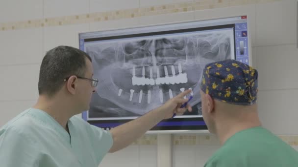 Close-up van twee artsen met x-ray wordt afgedrukt — Stockvideo