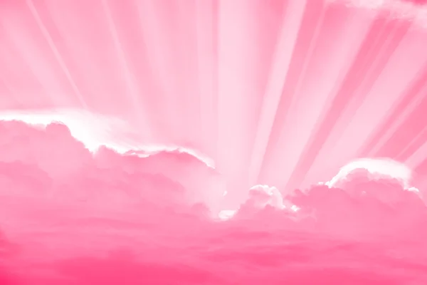 Pembe gökyüzü ve bulutlar ile aşağı parlayan ışık ışınları