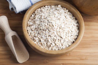 Yulaf ezmesi ya da kâsede yulaf ezmesi ve koyu ahşap masada kepçe.