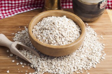 Yulaf ezmesi ya da kâsede yulaf ezmesi ve koyu ahşap masada kepçe.