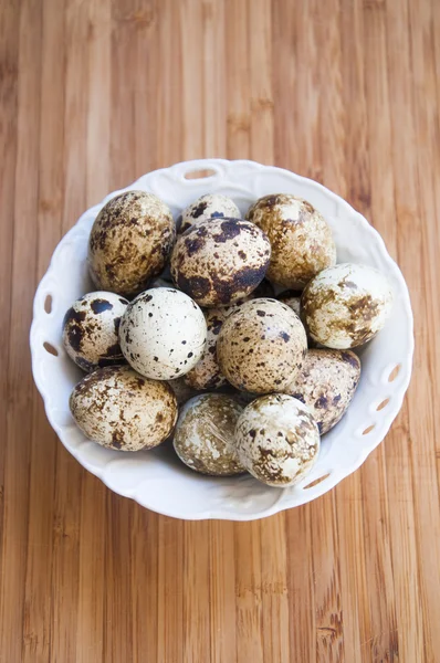 Quail eggs isolated on a wooden background — Stock Photo, Image