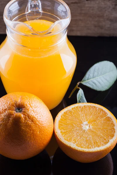 Kendi jus jeruk segar di atas meja hitam — Stok Foto