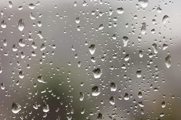 Abstrakce deště kapek na okenní sklo — Stock fotografie