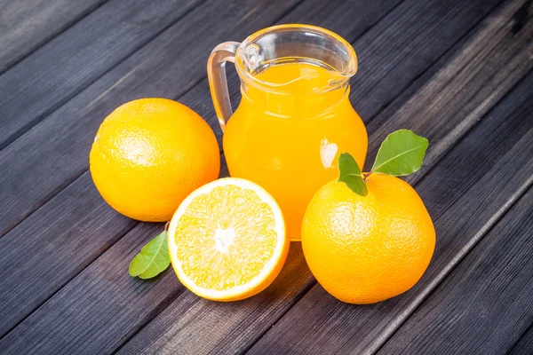 Oranges fraîches et jus sur la table nature morte — Photo