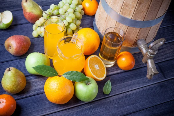 Obst und Saft in einem Holzfass auf dem Tisch Stillleben — Stockfoto