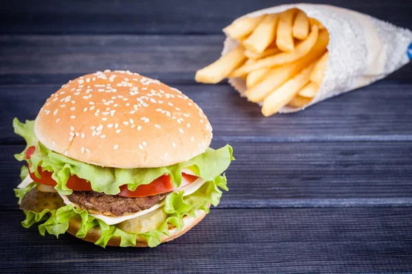 Street food cheeseburger and fries on the table — Stock Photo, Image