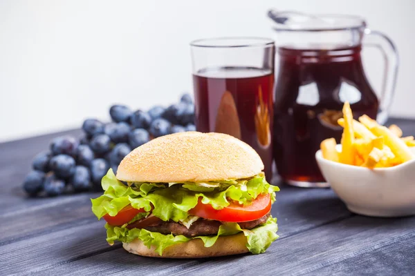 Grape juice, hamburger on the table — Stock Photo, Image