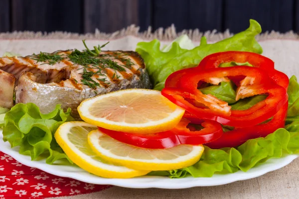 Porce smažené grilu steak z lososa a salát v talíř na stůl — Stock fotografie