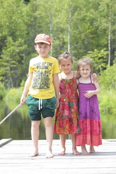 Tres niños felices sobre fondo verde del bosque — Foto de Stock