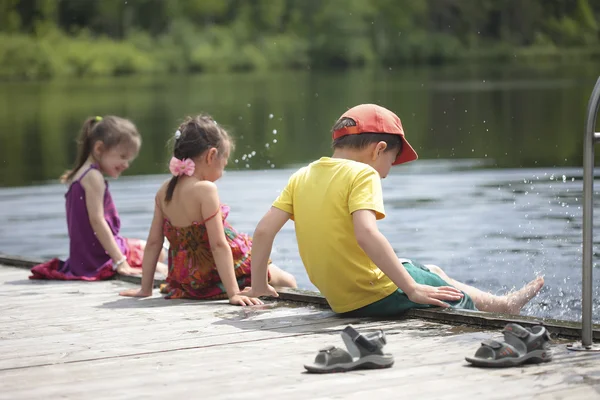 Trois enfants joyeux jouant sur le lac — Photo
