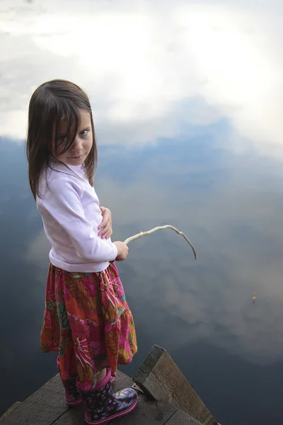 Porträt eines Mädchens, das im See fischt und den Himmel reflektiert — Stockfoto
