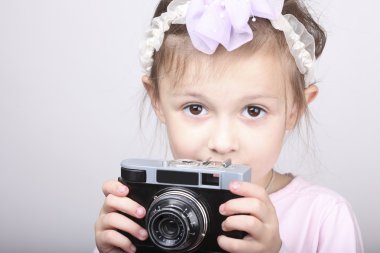 Eski bir vintage fotoğraf makinesi tutan genç kız