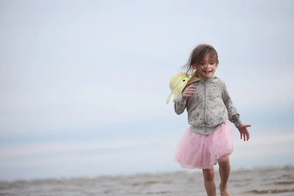 Petite fille allant dans les vagues contre la mer et le ciel — Photo