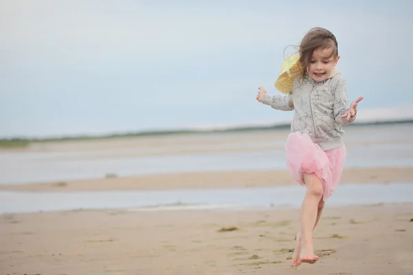 Petite fille courant sur le sable contre la mer et le ciel — Photo