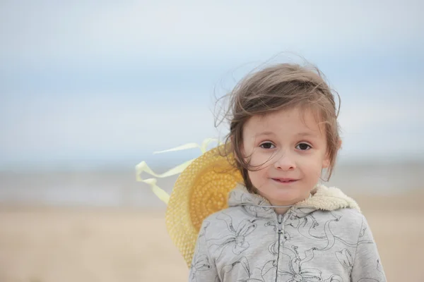 Porträt eines kleinen Mädchens, das an einer sandigen Meeresküste steht — Stockfoto