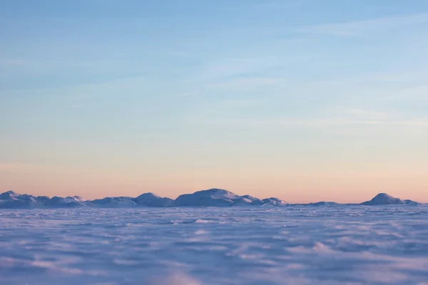 Desierto de nieve y cielo azul de invierno. Montañas en el horizonte —  Fotos de Stock