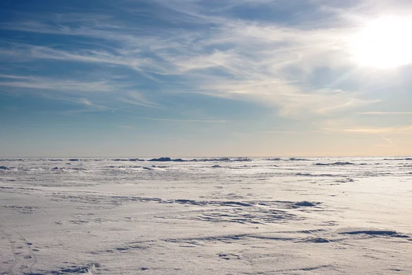 Snow desert and blue winter sky. Mountains on the horizon Stock Image