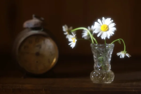 Stilizált homályos fénykép egy csokor virág és a régi órák — Stock Fotó
