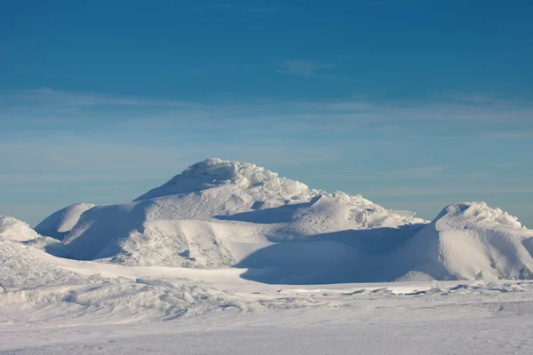 Desierto de nieve y cielo azul de invierno. Montañas en el horizonte —  Fotos de Stock