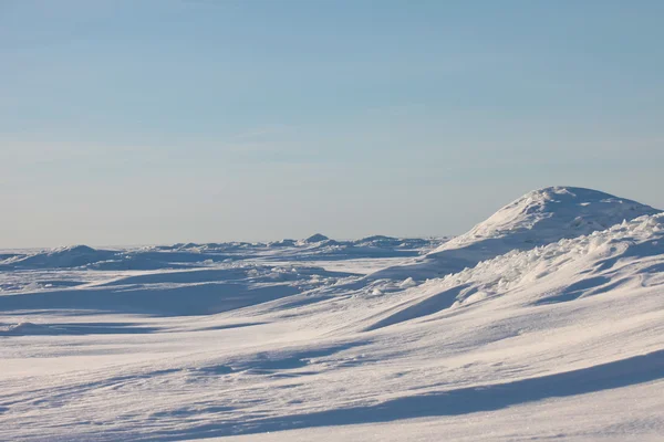 Desierto de nieve y cielo azul de invierno. Montañas en el horizonte —  Fotos de Stock