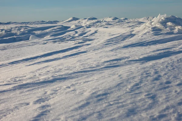 Desierto de nieve y cielo azul de invierno. Montañas en el horizonte —  Fotos de Stock