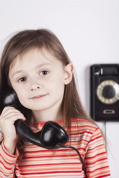 Ernstige kind praten over telefoon, witte achtergrond — Stockfoto