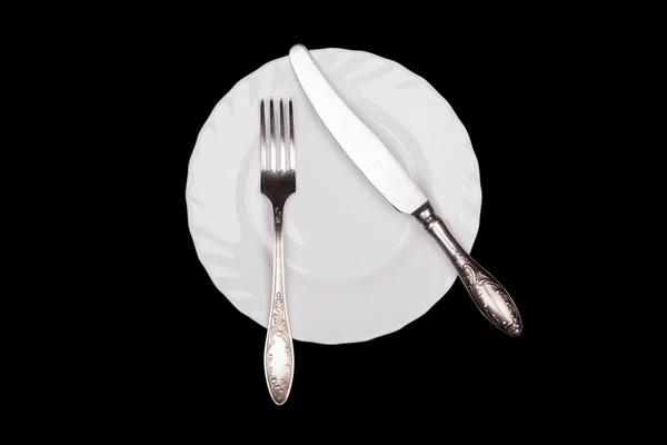 Etiquette teken. Plaat, vork, mes bovenaanzicht geïsoleerd op zwart — Stockfoto