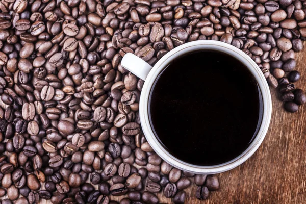 コーヒー カップとテーブルの上にコーヒー豆を表示します。 — ストック写真