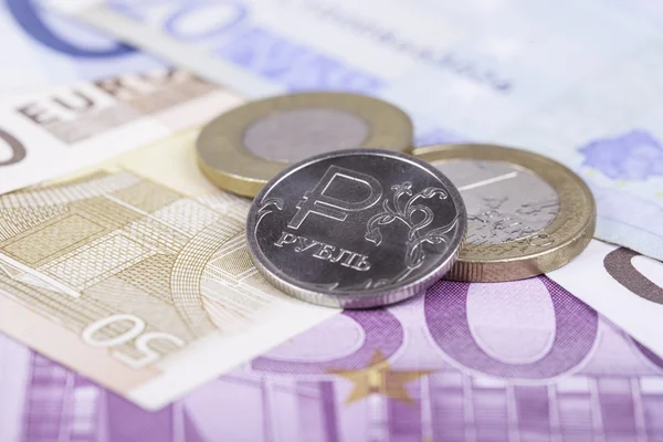 Монетный рубль на фоне банкнот евро — стоковое фото