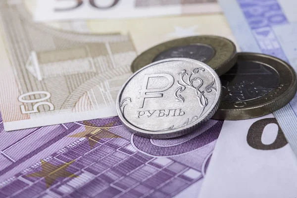Монетный рубль на фоне банкнот евро — стоковое фото