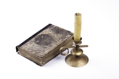 eski kitap ve beyaz zemin üzerine mum