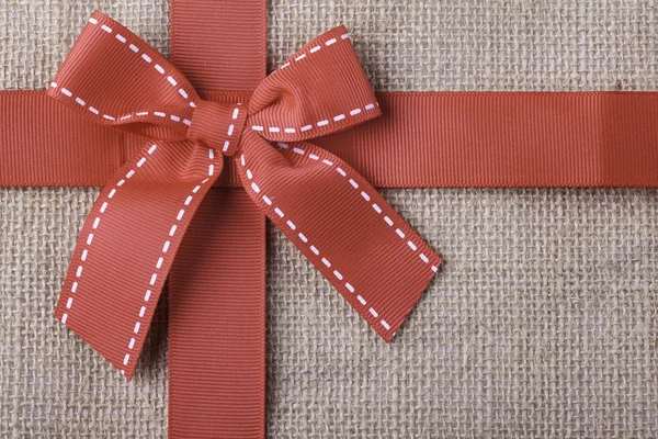 Bez arka plan closeup şeritte kırmızı hediye — Stok fotoğraf