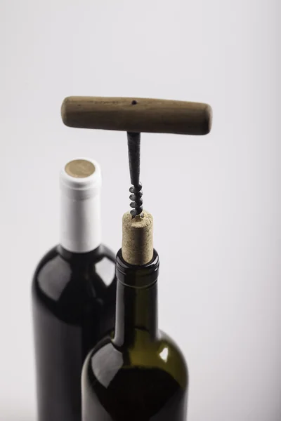 Две бутылки вина, штопор и штопор на белом фоне — стоковое фото
