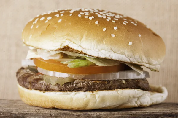 Burger closeup on an old wooden board vintage background — Stock Photo, Image