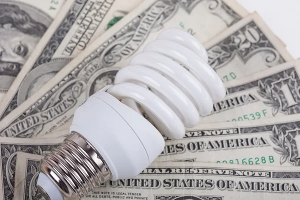 Energy saving lamp and dollars closeup Stock Picture