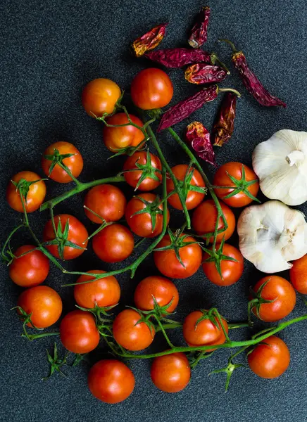Tomater, vitlök och röd paprika mot en mörk bakgrund — Stockfoto